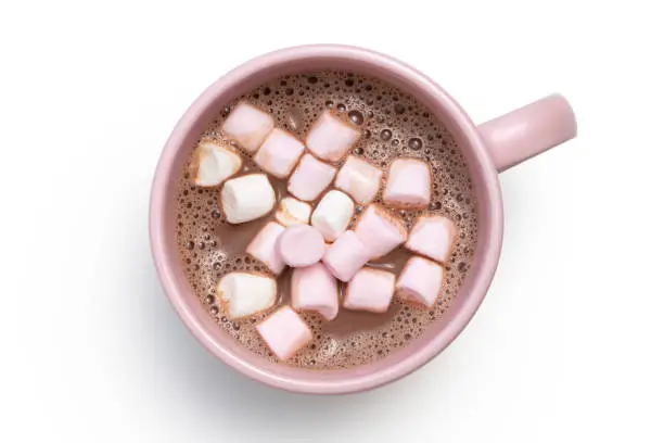 Hot chocolate with small pink and white marshmallows in a pink ceramic mug isolated on white from above.