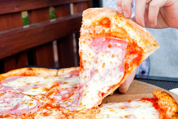 istock A boy picking up a slice of pizza. 1162716882
