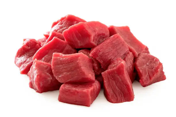 Photo of Pile of beef cubes isolated on white.
