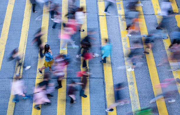 istock Young woman standing out, with phone, in motion blurred crowd 1162717886