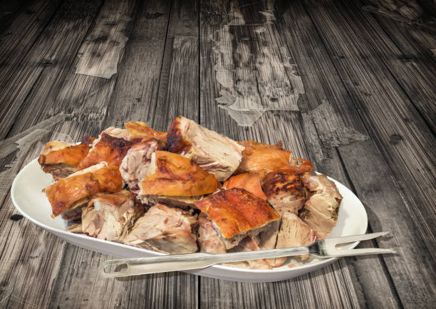 plateful of freshly spit roasted pork shoulder chunks served on old weathered rustic wooden backdrop - roasted spit roasted roast pork barbecue grill imagens e fotografias de stock