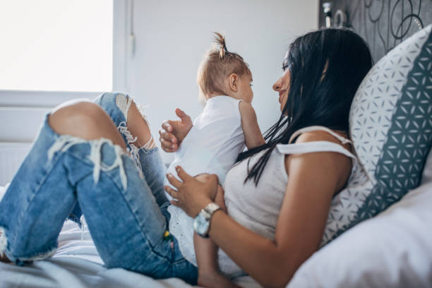 istock Young mom holding a beautiful baby in bed 1162720282