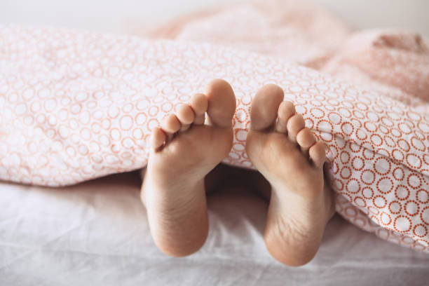 istock Feet girls under a blanket 1162722022