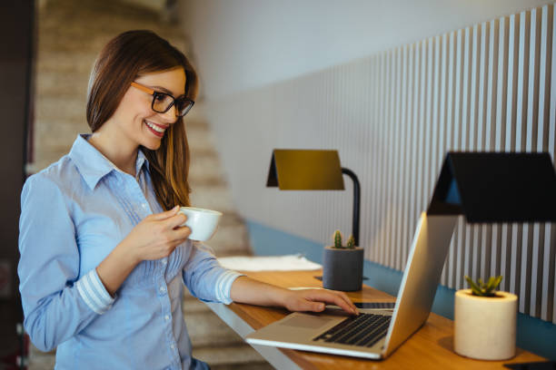 istock Relaxed young businesswoman having coffee while working on laptop 1162723179