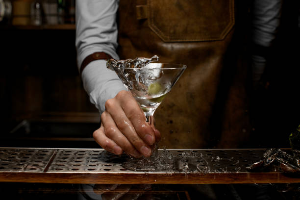 istock Bartender mixing a transparent alcoholic drink in the martini glass with one olive 1162723411