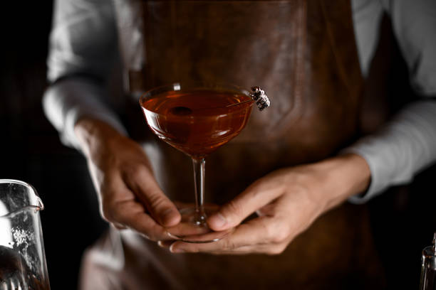 Bartender serving a cocktail in the glass decorated with metal bear