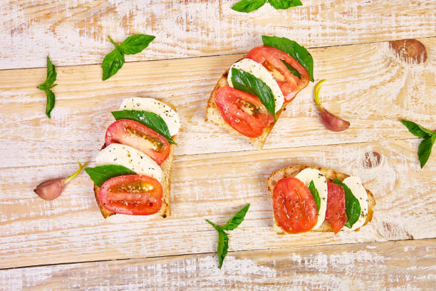 bruschetta com tomates, queijo mozzarella e manjericão - mozzarella salad caprese salad olive oil - fotografias e filmes do acervo