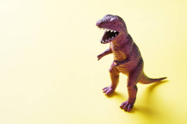 istock Dinosaur on a yellow background. Plastic rubber toy. Selective focus. 1162726061