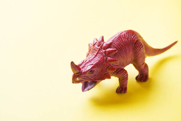 istock Dinosaur on a yellow background. Plastic rubber toy. Selective focus. 1162726089