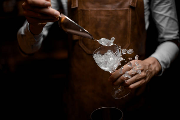 Professional bartender putting crushed ice to the glass