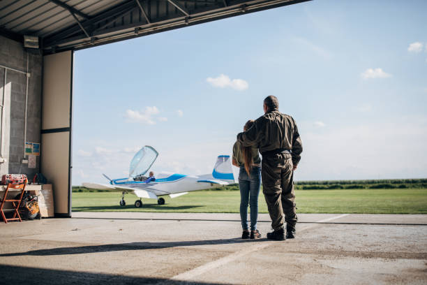 istock Dad pilot and daughter looking at propeller airplane 1162726716