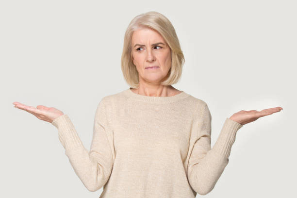 istock Confused old woman headshot having doubt making choice 1162731030