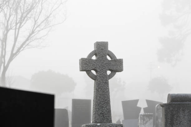 istock Celtic stone cross in misty, mysterious cemetery 1162732525