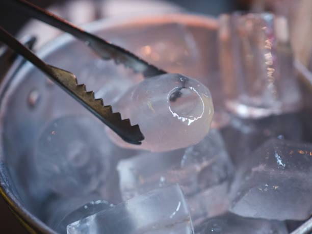 cubo de hielo de cerca con la mano sosteniendo hielo es un enfoque limpio y sensible - ice machine fotografías e imágenes de stock