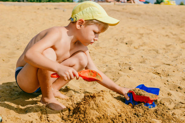 istock boy playing with a machine in the sand 1162735919