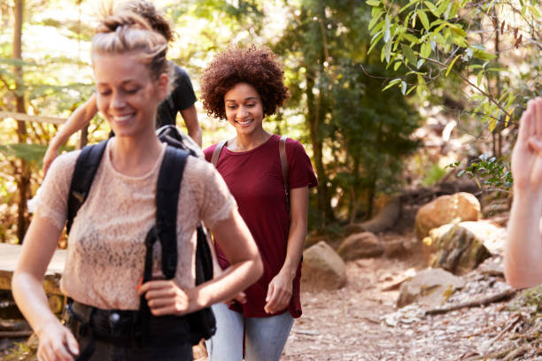 istock Millennial girlfriends walking together during a hike in a forest, close up 1162737417