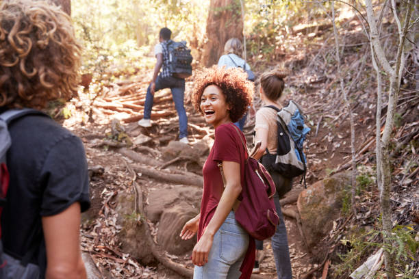 grupa milenialsów przyjaciół wędruje pod górę leśnym szlakiem o długości trzech czwartych - tree quarter length zdjęcia i obrazy z banku zdjęć