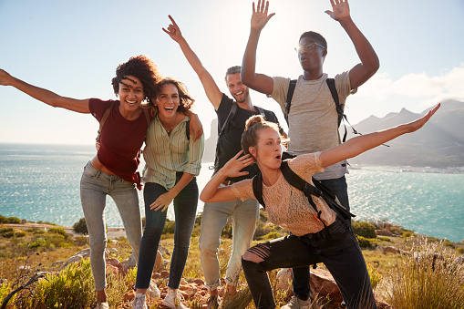Amigos millennials en un viaje de senderismo celebran llegar a la cumbre y divertirse posando para fotos photo