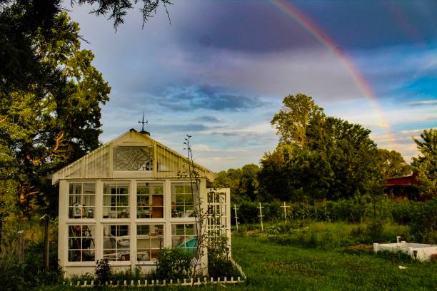 istock Dramatic Rainbow and clouds over beautiful garden and greenhouse 1162742038