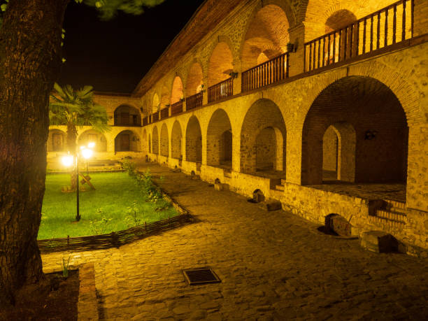 une vue de nuit de la cour de caravan saray (ou logement de caravane) à sheki, azerbaïdjan. le bâtiment est du 18ème siècle. - lodging photos et images de collection