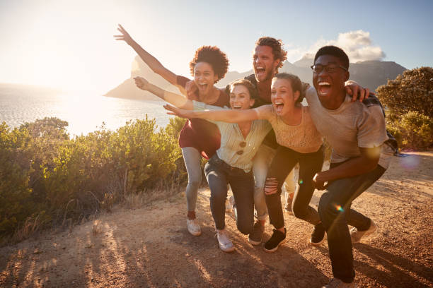 istock Five millennial friends on a road trip have fun posing for photos on a coastal path, full length 1162746285