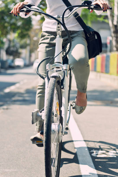 istock Low Section Of Woman Riding Bicycle On Road 1162746341