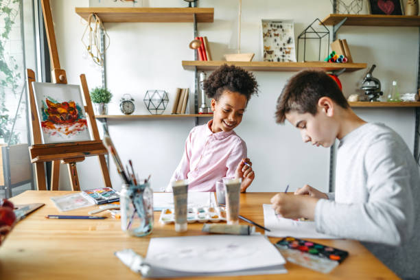 istock Multiethnic children drawing at table with watercolor 1162750144