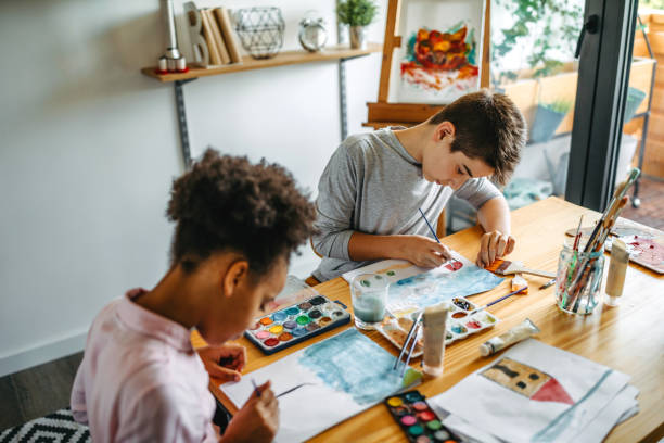 istock Multiethnic children drawing at table with watercolor 1162750427