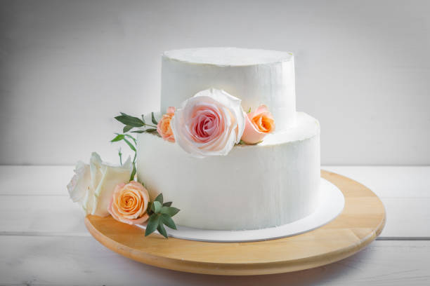 istock White wedding two-tiered cake decorated with flowers 1162751649