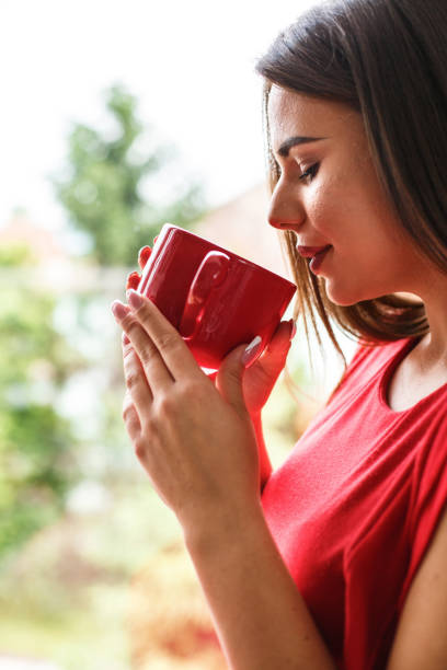 istock Woman drinking tea by the window 1162753918