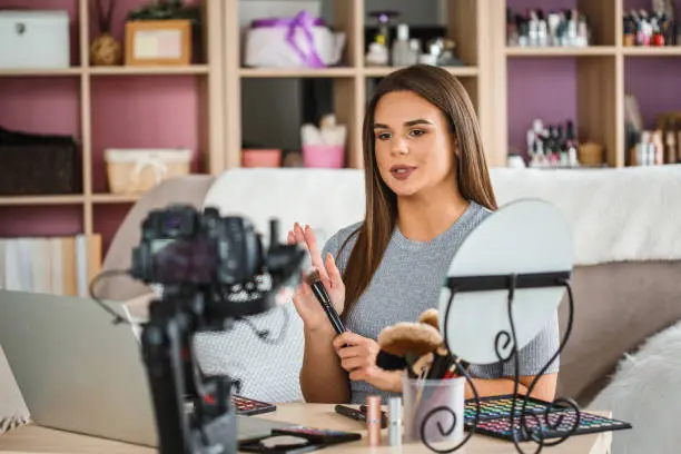 Photo of Vlogger creating beauty video podcast at home