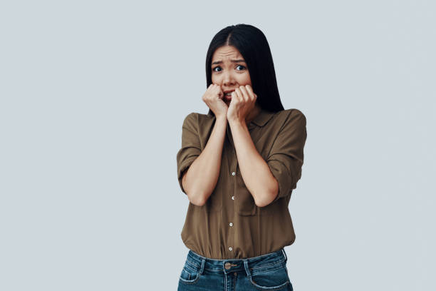 istock Worried. Confused young Asian woman making a face while standing against grey background 1162756783