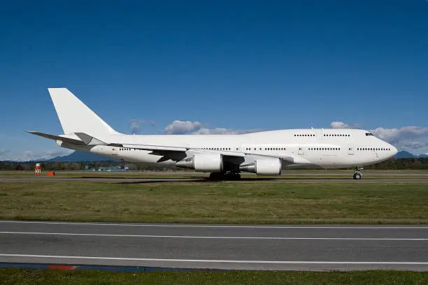 An all-white Boeing 747 taxiing to for departure.