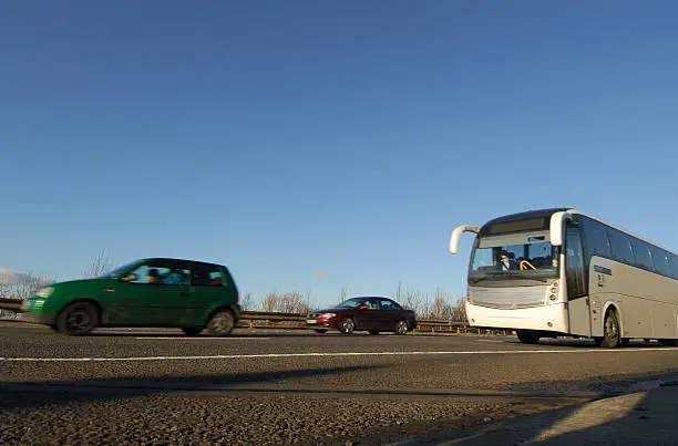 Coach and cars passing on motorway/freeway, shot from low angle with motion blur.