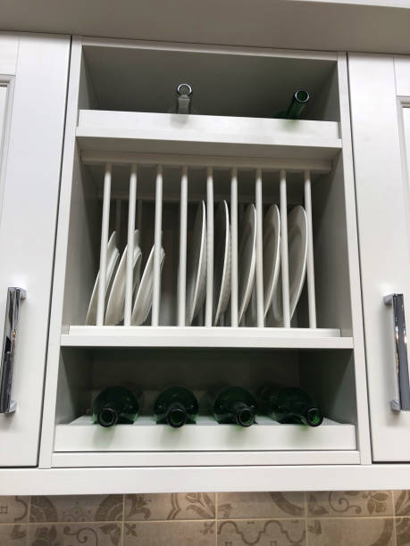 Stock photo of traditional wooden kitchen cabinets painted white / grey with fitted plate rack shelving, wine rack bottle holder, dinner plates on show and hidden concealed under cupboard lighting lights, square patterned kitchen tiles and chrome door handles imagen de los gabinetes tradicionales de cocina de madera pintados de blanco / gris con estanterías de estante de placas ajustadas, portabotellas de estante de vino, platos de cena en exhibición y oculto oculto bajo luces de iluminación de armario, azul