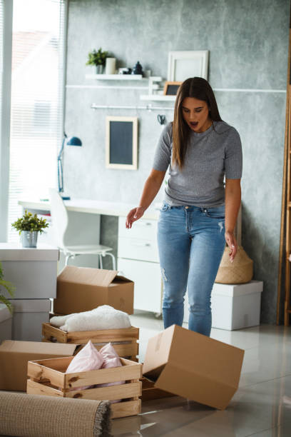 istock Clumsy woman dropping moving box 1162759489