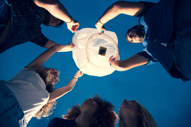 istock Friends celebrating birthday with a paper lantern at party 1162761268