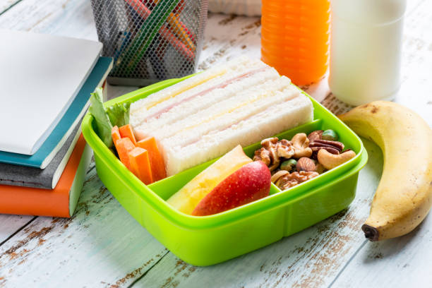 ニンジンとミックスナッツ、リンゴ、バナナ、オレンジジュースの牛乳入りハムチーズサンドイッチのランチボックスセット。学校のための子供のお弁当パック。 - lunch box packed lunch school lunch lunch ストックフォトと画像