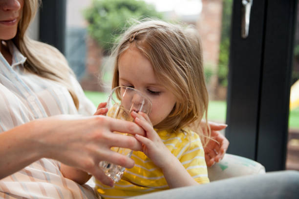 istock Mother Helping Her Daughter Drinking Water 1162761726