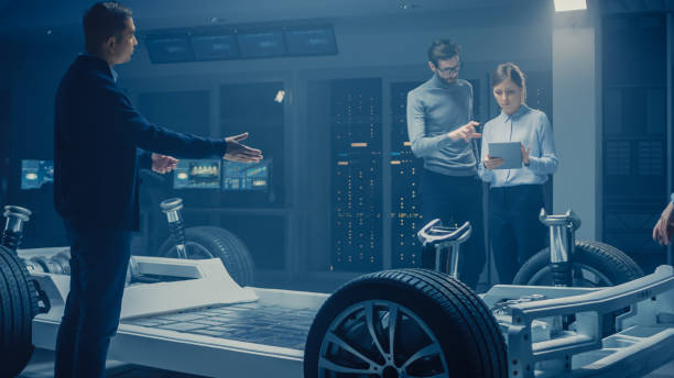 istock Automobile Engineers Discussing and Designing Electric Car Chassis Platform, Using Tablet Computers with 3D CAD Software. In Automotive Innovation Facility Vehicle Frame with Wheels, Engine and Battery 1162762173
