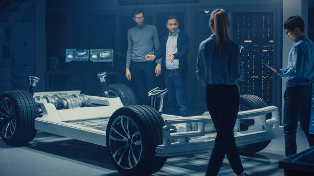 istock Team of Automotive Engineers Working on Electric Car Chassis Platform, Taking Measures, working with 3D CAD Software, Analysing Efficiency. Vehicle Frame with Wheels, Engine and Battery. 1162762366