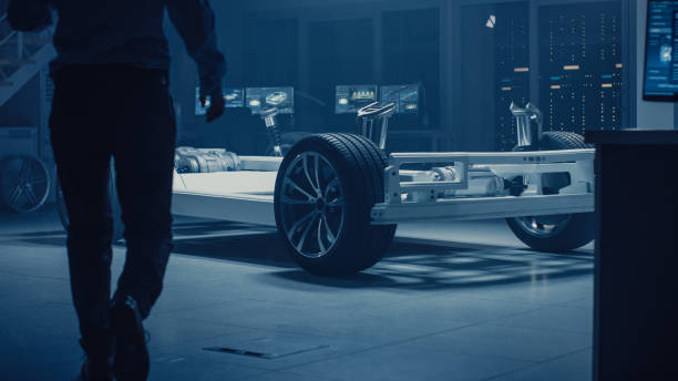 istock Automobile Engineer Enter Automotive Innovation Facility to Work on Electric Car Chassis Platform, Using Augmented Reality with 3D CAD Software Modelling. Innovative Facility: Vehicle Frame with Wheels, Engine, Battery 1162762375