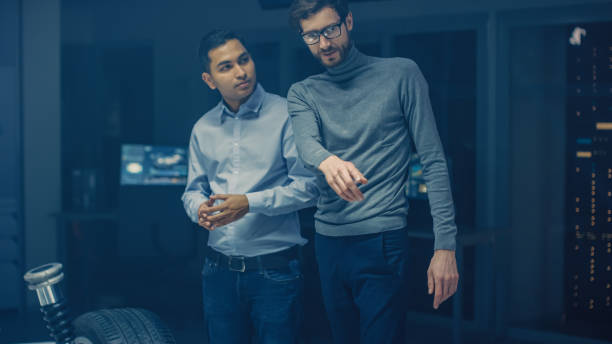 istock Automobile Engineers Discussing and Designing Electric Car Chassis Platform. In Automotive Innovation Facility Vehicle Frame with Wheels, Engine and Battery 1162762432