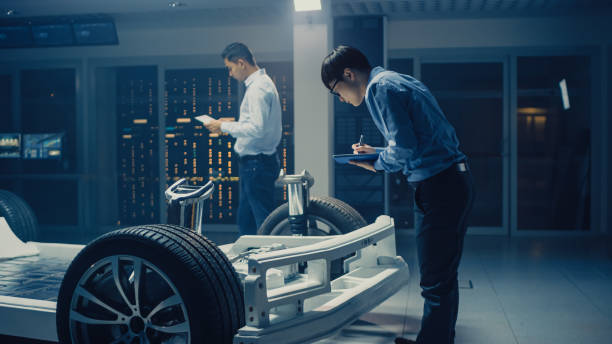 istock Automotive Engineers Working on Electric Car Chassis Platform, Taking Measures, working with 3D CAD Software, Analysing Efficiency. Vehicle Frame with Wheels, Engine and Battery 1162762436