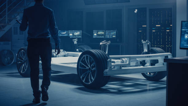 istock Automobile Engineer Enter Automotive Innovation Facility to Work on Electric Car Chassis Platform, Using Augmented Reality with 3D CAD Software Modelling. Innovative Facility: Vehicle Frame with Wheels, Engine, Battery 1162762461