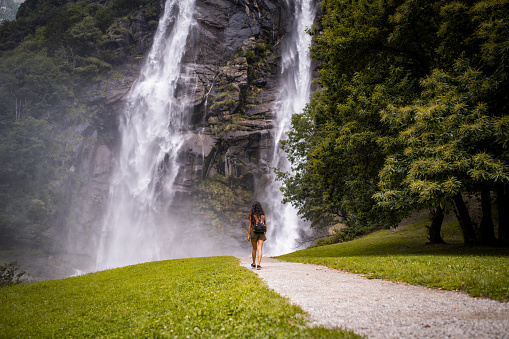 Beautiful smiling Latin woman visiting beautiful waterfall