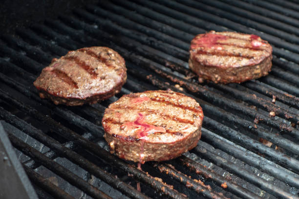 istock summer close up beef hamburger BBQ on a propane gas grill 1162763350