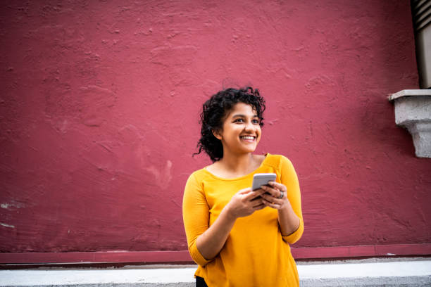 istock Smiling Indian woman using mobile phone 1162766222