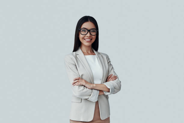 istock Young and smart. Attractive young Asian woman looking at camera while standing against grey background 1162767165