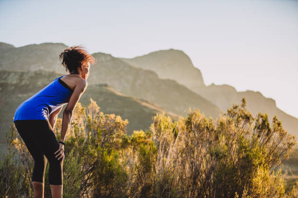 This is a tired that I enjoy Shot of a sporty young woman catching her breath after a run outdoors hand on knee stock pictures, royalty-free photos & images